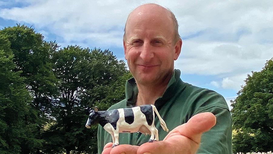 Sam Foot holding figure of small cow